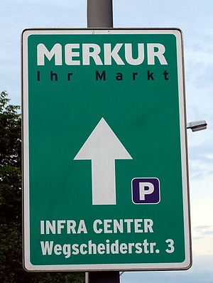 Wegweiser/Werbetafel zum Merkur-Markt im Infra Center