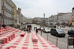 Der rot/weiß/rosa bemalte Vorplatz vor dem Linz09-Informationszentrum, am Hauptplatz